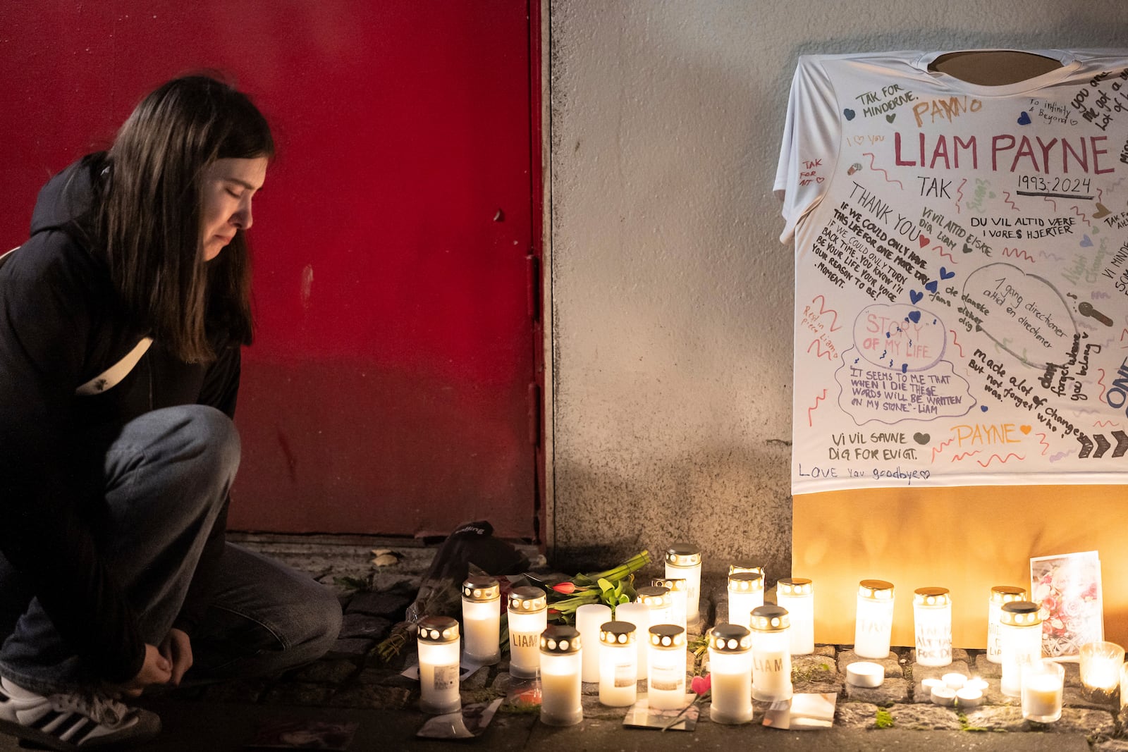 A girl reacts next to a makeshift althar for the deceased singer Liam Payne is pictured at Forum in Copenhagen, Thursday, Oct. 17, 2024. (Emil Nicolai Helms/Ritzau Scanpix via AP)