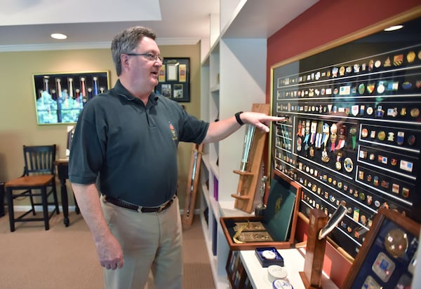 Scott Reed shows off a collection of Olympic pins at his home in Lilburn.  Reed’s hobby took him to Sydney, Nagano, Japan; Lausanne, Switzerland; and London. HYOSUB SHIN / HSHIN@AJC.COM