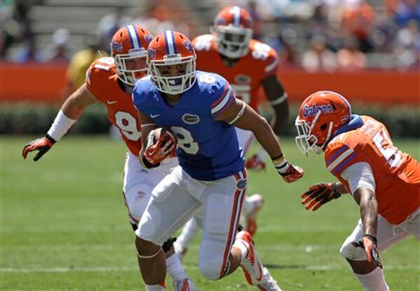 Florida running back Trey Burton (8) looks for a way around linebacker Michael Taylor, right, and Joey Ivie, left, during a spring NCAA college football scrimmage, Saturday, April 6, 2013, in Gainesville, Fla. (AP Photo/John Raoux) Florida's Trey Burton (8) looks for a way around linebacker Michael Taylor, right, and Joey Ivie, left, during a spring NCAA college football scrimmage, Saturday, April 6, 2013, in Gainesville, Fla. (AP Photo/John Raoux)