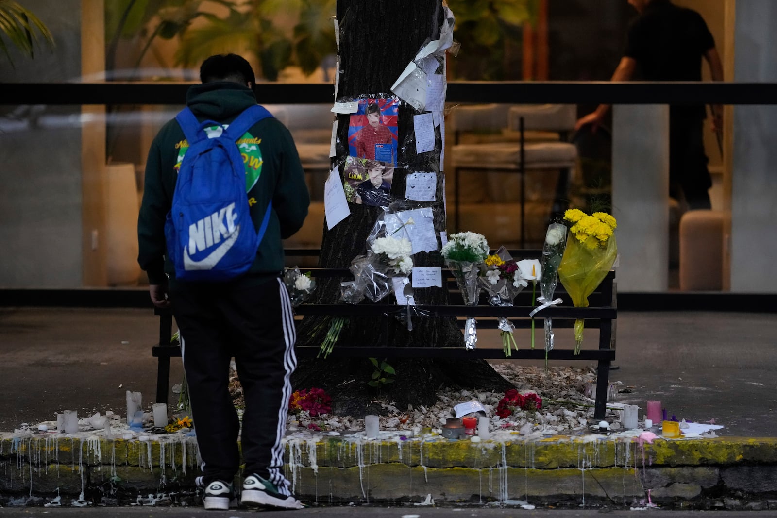 A fan stands in front of a makeshift memorial outside the hotel where former One Direction singer Liam Payne was found dead after falling from a balcony in Buenos Aires, Argentina, the morning after his death, Thursday, Oct. 17, 2024. (AP Photo/Natacha Pisarenko)