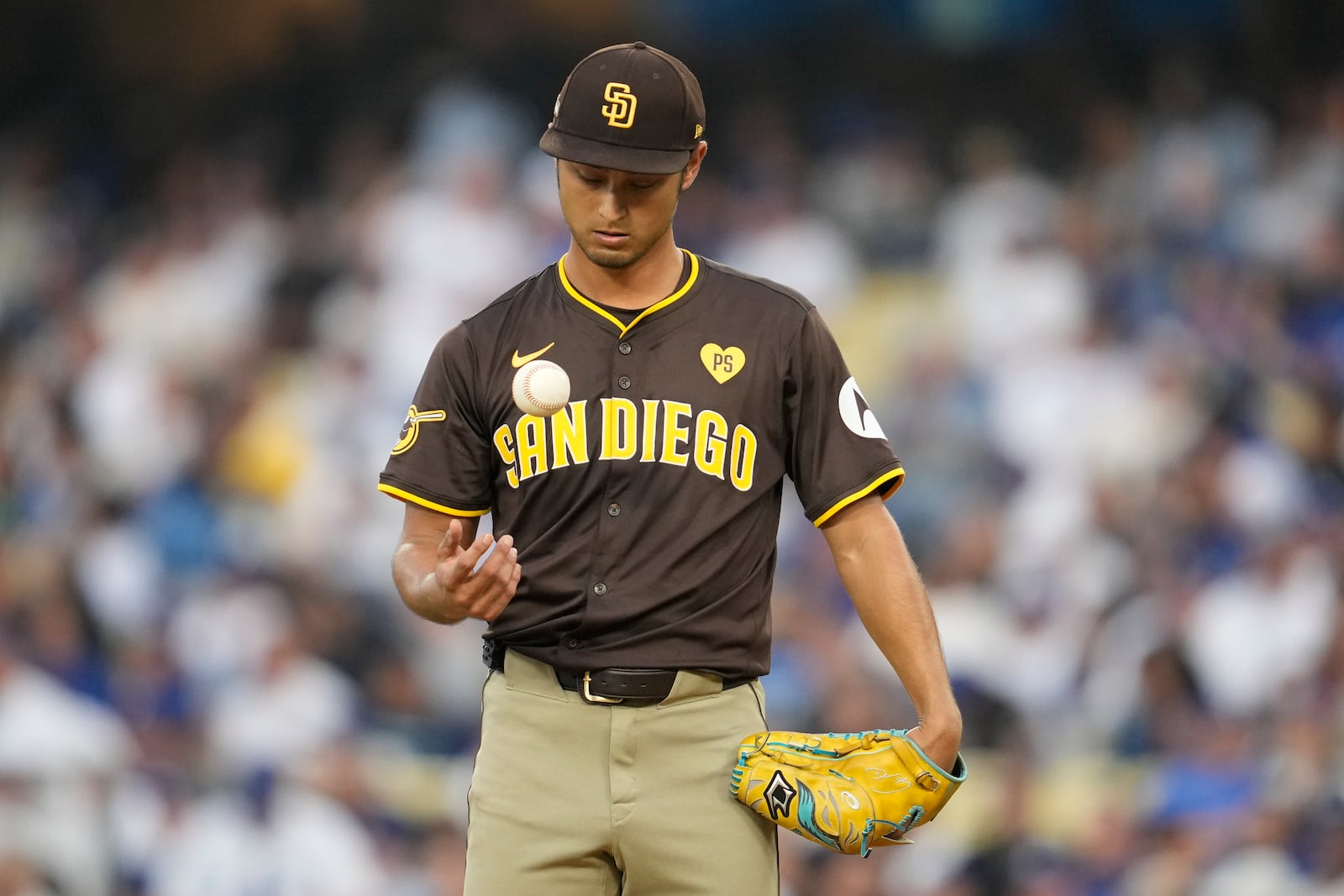 San Diego Padres pitcher Yu Darvish juggles the baseball on the mound during the fourth inning in Game 5 of a baseball NL Division Series against the Los Angeles Dodgers, Friday, Oct. 11, 2024, in Los Angeles. (AP Photo/Ashley Landis)