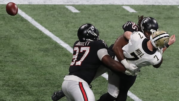 Falcons Grady Jarrett (left) and Steven Means hit New Orleans Saints quarterback Taysom Hill forcing a fumble the Falcons recovered during the fourth quarter Sunday, Dec. 6, 2020, at Mercedes-Benz Stadium in Atlanta. (Curtis Compton / Curtis.Compton@ajc.com)