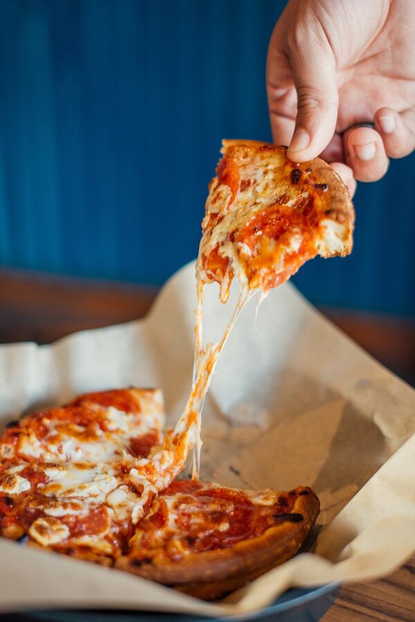 Guests at the Springs Cinema & Taphouse can take a freshly baked pizza into their movie and enjoy it at one of the built-in tables. CONTRIBUTED BY JARROD CECIL PHOTOGRAPHY