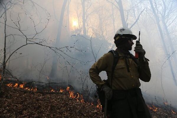 Squad boss Layne Whitney communicates with his fire crew while they battle the Rock Mountain fire in Rabun County. CURTIS COMPTON / CCOMPTON@AJC.COM