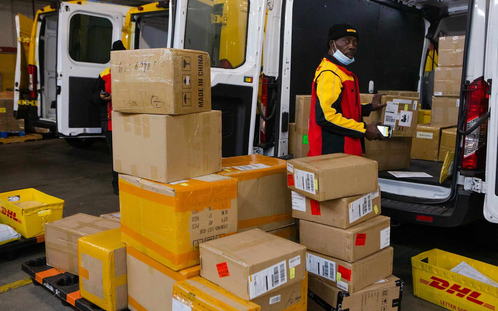 Babatunde Anezi sorts packages on Wednesday, December 16, 2020, at DHL Express in Atlanta. Workers at the shipping center worked to fulfill orders during the holiday rush. CHRISTINA MATACOTTA FOR THE ATLANTA JOURNAL-CONSTITUTION.