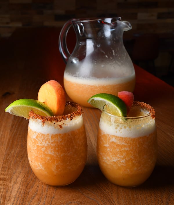 Bar(n) Booze (n) Bites' The Spicy Peach Margarita, made by Phil Handley, a partner with DASH Hospitality Group, is a frozen combination that includes peach puree, tequila, lime juice and agave nectar. (Styling by Phil Handley / Chris Hunt for the AJC)