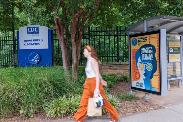 A person walks in front of the CDC entrance on Clifton Road, Which is near a MARTA stop, in Atlanta on Tuesday, August 2, 2022. (Arvin Temkar / arvin.temkar@ajc.com)