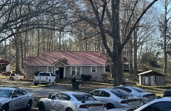 Carroll County Sheriff Office investigators scour the scene of a double shooting at a home a few miles southwest of Carrollton on Thursday.