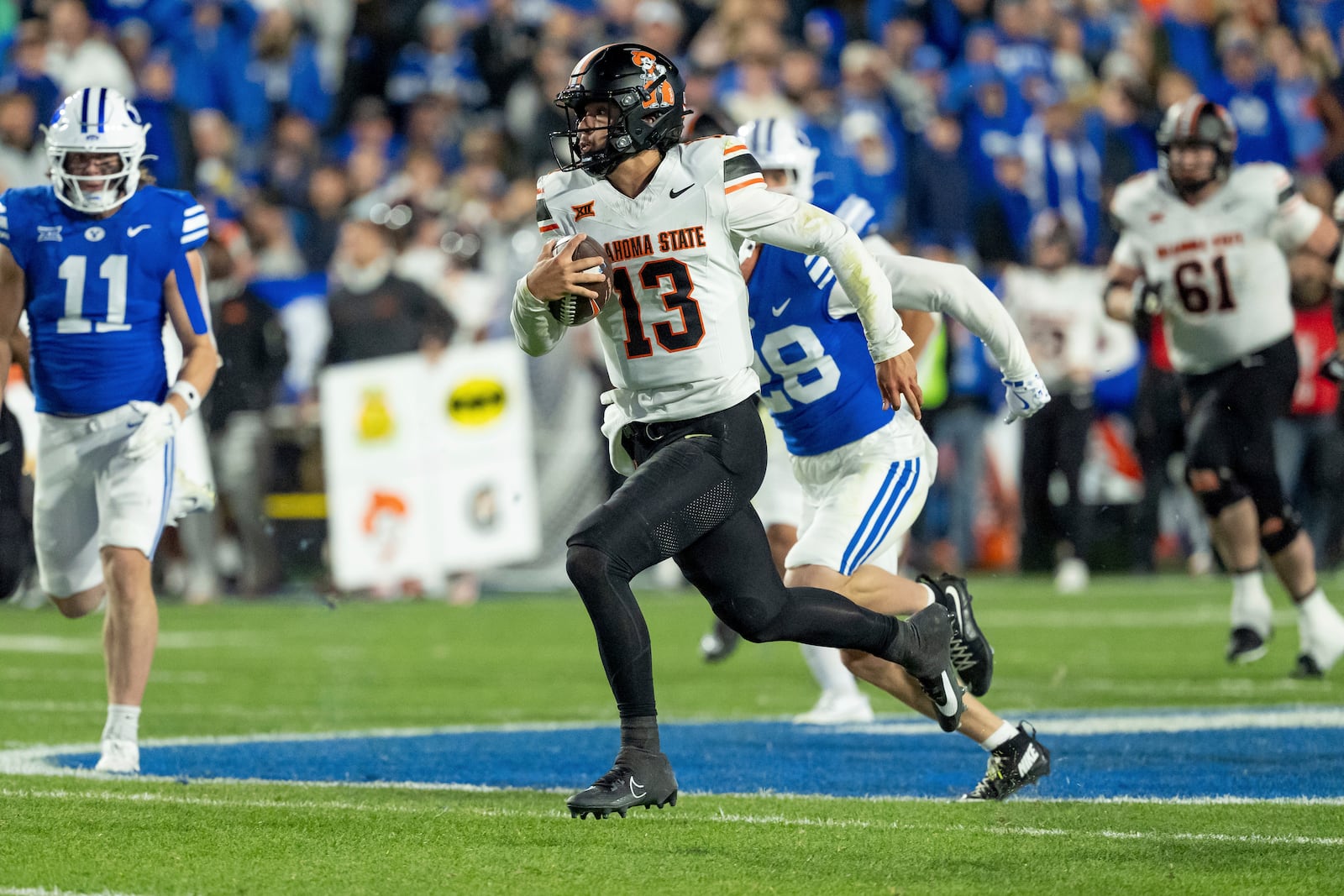 Oklahoma State quarterback Garret Rangel (13) runs the ball in the first half of an NCAA college football game against BYU, Friday, Oct. 18, 2024, in Provo, Utah. (AP Photo/Spenser Heaps)