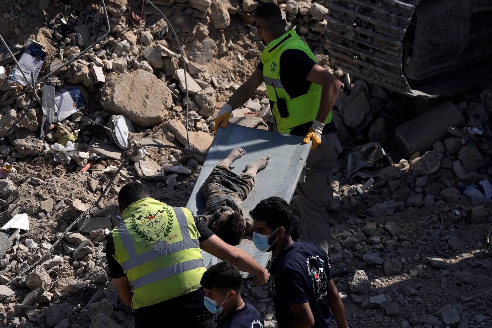 Emergency workers carry the body of a victim found in the rubble of a destroyed building hit Tuesday night in an Israeli airstrike in Sarafand, south Lebanon, Wednesday, Oct. 30, 2024. (AP Photo/Bilal Hussein)