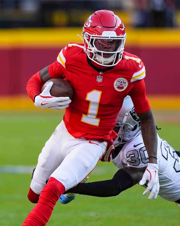 Kansas City Chiefs wide receiver Xavier Worthy (1) is tackled by Las Vegas Raiders cornerback Darnay Holmes (30) during the first half of an NFL football game in Kansas City, Mo., Friday, Nov. 29, 2024. (AP Photo/Charlie Riedel)