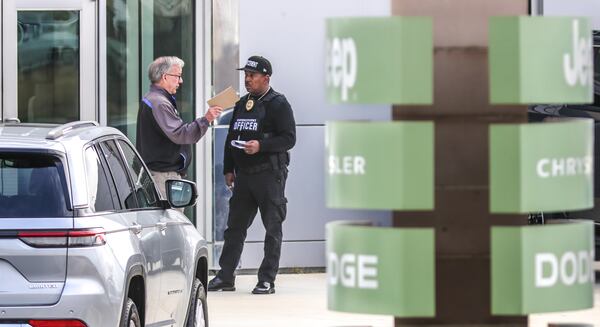 February 21, 2022 Stonecrest: Willie Kelsey with Enforcement security (right) came to the dealership on Monday, Feb. 21, 2022 to inquire about doing security for the dealership after hearing about the shooting death of a guard there over the weekend. DeKalb County police are investigating after a security guard was shot and killed at a car dealership near the Mall at Stonecrest on Saturday night, officials said. Officers were called around 11 p.m. to the area of 8455 Mall Parkway, DeKalb police spokesperson Michaela Vincent said. They found Henry Ashley, who worked as a security guard at the Courtesy Chrysler Dodge dealership near the mall, with a gunshot wound. He was taken to a hospital, where he died. Investigators determined Ashley, 24, was investigating a suspicious person alert on the property when he encountered a group of suspects, according to a news release. Moments later, he was shot while in his marked work vehicle. In a still of security camera footage released by police, at least five suspects can be seen walking through the dealership’s parking lot. No suspects have been arrested, the news release states. Police are asking the public for help in identifying the five suspects. In an interview with Channel 2 Action News, the victim’s wife said she had been on the phone with him just minutes before the shooting. “I have to stay strong for my son,” Kyla Rushton said. “He lost his daddy. I hope whatever they wanted here was more important than his life.” Police searching for 5 suspects after 24-year-old security guard shot, killed at car dealership Police ask anyone with information about the incident to call detectives at 770-724-7850 or to contact Crime Stoppers Atlanta by calling 404-577-8477, texting information to 274637 or visiting the Crime Stoppers website. Tipsters may be eligible to receive up to a $2,000 reward. (John Spink / John.Spink@ajc.com)

