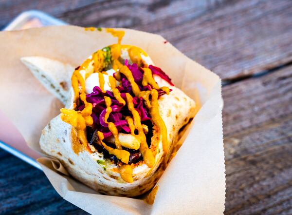 Sabich, a pita filled with eggplant, hummus, boiled egg, Israeli salad, amba and harissa, at Falafel Nation. CONTRIBUTED BY HENRI HOLLIS