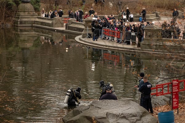 NYPD officers in diving suits search a lake in Central Park, Monday, Dec. 9, 2024, in New York. (AP Photo/Yuki Iwamura)