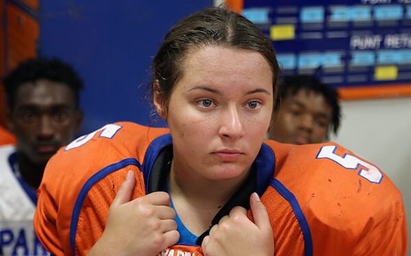 Hollywood Hills quarterback Holly Neher, 16, is trying out for the football team. Neher listens to the coach as he talks with the team inside the locker room. (Carl Juste/Miami Herald/TNS)