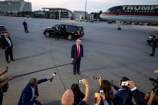 Former President Donald Trump speaks to reporters at Hartsfield-Jackson International Airport after surrendering earlier at the Fulton County Jail On Aug. 24. Trump is one of 19 defendants in an indictment Fulton District Attorney Fani Willis brought alleging a "criminal enterprise" that sought illegally to overturn the 2020 presidential election in Georgia. (Doug Mills/The New York Times)
                      