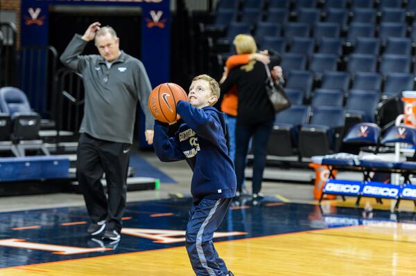 Georgia Tech assistant coach Tom Herrion and family - wife Leslie, son Robert. Robert Herrion shoots baskets at Virginia's John Paul Jones Arena in January. (GT Athletics/DANNY KARNIK)