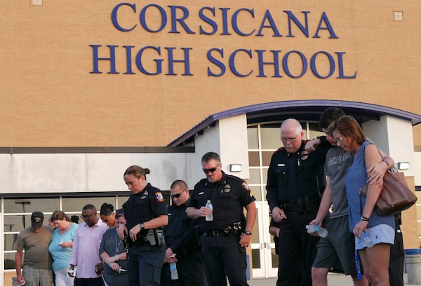 Corsicana, Texas - Two armed police officers (background) keep watch from the roof of Corsicana High School during a candlelight vigil to honor Brent Thompson, the Dallas Area Rapid Transit officer killed in the Thursday night attack, at Corsicana High School in Corsicana on Sunday, July 9, 2016. Thompson was a Corsicana native, a graduate of Corsicana High and a former officer for both the city and Corsicana ISD. Thompson was the first of the five fallen officers in the Dallas shooting to be named. HYOSUB SHIN / HSHIN@AJC.COM