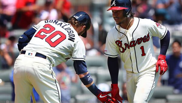 Braves' Ozzie Albies celebrates with Josh Donaldson hitting a leadoff home run Sunday, April 28, 2019, against the Colorado Rockies at SunTrust Park  in Atlanta.