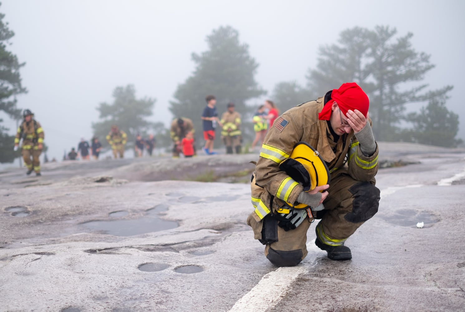 Gwinnett Firefighter Johnathan Simcox takes a knee while climbing Stone Mountain on Sunday morning, Sept. 11, 2022, during the annual remembrance of the 9/11 terrorist attacks. (Photo: Ben Gray for The Atlanta Journal-Constitution)