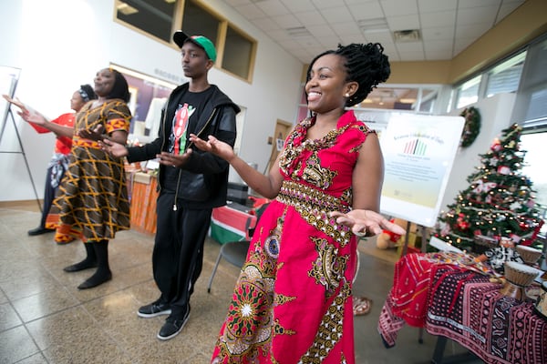 Carol Kariuki, far right, joins, from left, Theresa Garcia, Elizabeth Kahura and Andrew Kahura, 14, as they encourage the audience dance along with them during a Kwanzaa Celebration at the George Washington Carver Museum on Friday, December 26, 2014. The event was celebrating the first day of Kwanzaa which focuses on Unity (Umoja). DEBORAH CANNON / AMERICAN-STATESMAN