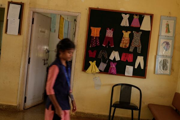 A student enrolled for a professional training course walks past a display of clothes stitched by tailors who use electric sewing machines to make clothes, at the campus of the Swami Vivekananda Youth Movement, a nongovernmental organization that works to help poor and Indigenous communities, in Kenchanahalli, India, Monday, Sept. 23, 2024. (AP Photo/Aijaz Rahi)