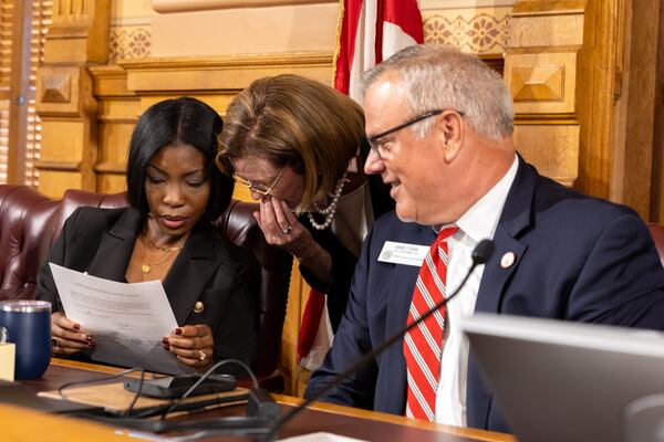 State Election Board members Janelle King (left) and Janice Johnston (center) as well as executive director Mike Coan, chat before a board meeting in Atlanta on Friday.