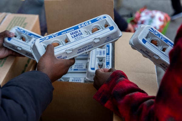 Abou Sow hands out cartons of eggs to people waiting in line to receive free eggs from FarmerJawn Agriculture, Friday, March 21, 2025, in the Harlem neighborhood of New York. (AP Photo/Julia Demaree Nikhinson)