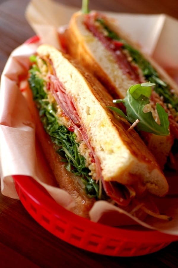 Pan De Jamon Y Queso with Serrano ham, Manchego cheese, almond-date spread and arugula. (El Super Pan)