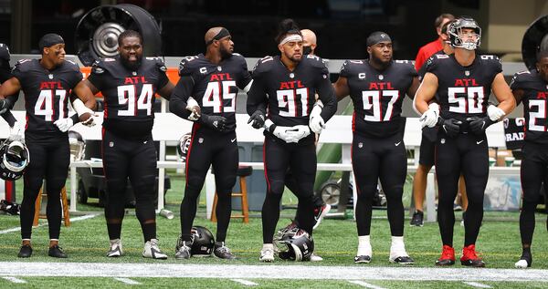 091320 Atlanta: Atlanta Falcons players join arms for the national anthem to begin the season opening game against the Seattle Seahawks Sunday, Sept. 13, 2020, at Mercedes-Benz Stadium in Atlanta.  (Curtis Compton / Curtis.Compton@ajc.com)