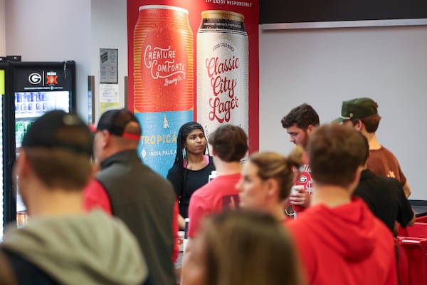 A poster for Creature Comfort Brewing Company is shown on the wall of a concession as employees sell beer to Georgia fans before Georgia’s men’s basketball game against Alabama at Stegemen Coliseum, Wednesday, January 31, 2024, in Athens, Ga. (Jason Getz / jason.getz@ajc.com)