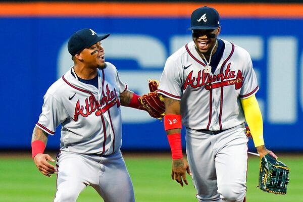 Atlanta Braves' Orlando Arcia, left, celebrates with Ronald Acuna Jr.  after Acuna caught a ball hit by New York Mets' Pete Alonso at the wall during the first inning of a baseball game Friday, Aug. 5, 2022, in New York. (AP Photo/Frank Franklin II)