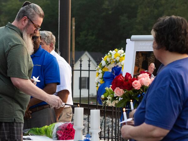 Scott Leavitt Jr. lights a candle during a candlelight vigil for his father, Scott Leavitt Sr. The elder Leavitt was one of the victims of a mass shooting over the weekend in the south metro Atlanta community. (Michael Blackshire / Michael.Blackshire@ajc.com)