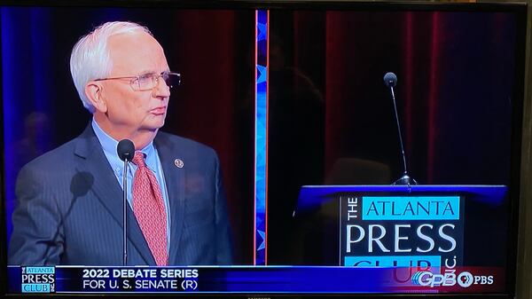 Gary Black poses a question to an empty podium representing Herschel Walker 