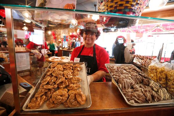 Trinity Nash slides a tray of pralines into the case inside the newest River Street Sweets location at 32 E. Broughton Street.