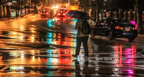 Pedestrians deal with wet weather at Luckie Street and Centennial Olympic Park Drive. JOHN SPINK / JSPINK@AJC.COM