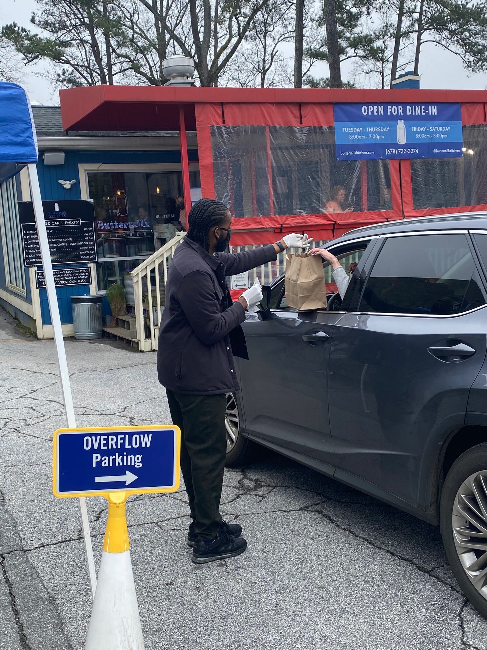 Buttermilk Kitchen Assistant General Manager Julian Guzman handles curbside pickup orders on a busy Saturday morning. Ligaya Figueras/ligaya.figueras@ajc.com
