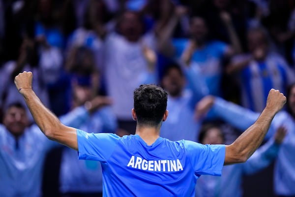 Argentina's Francisco Cerundolo celebrates after winning a Davis Cup quarterfinal match against Italy's Lorenzo Musetti at the Martin Carpena Sports Hall in Malaga, southern Spain, on Thursday, Nov. 21, 2024. (AP Photo/Manu Fernandez)