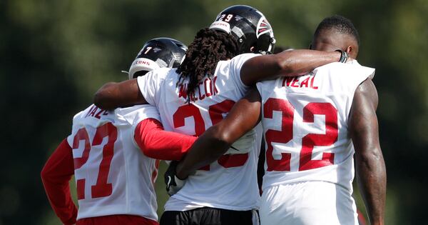 Falcons defensive back J.J. Wilcox (29) is helped off the field by teammates Damontae Kazee (27) and strong safety Keanu Neal (22) after being injured during a training camp practice Monday, July 22, 2019, in Flowery Branch.