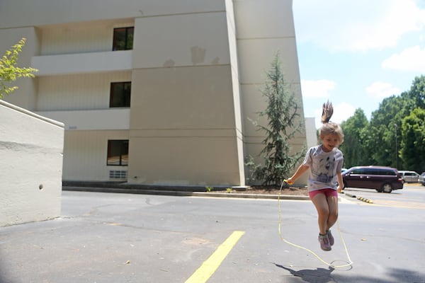 Sarah Schroeder, 8, jumps rope in the parking lot at the extended-stay motel where her family has been living. CHRISTINA MATACOTTA / CHRISTINA.MATACOTTA@AJC.COM