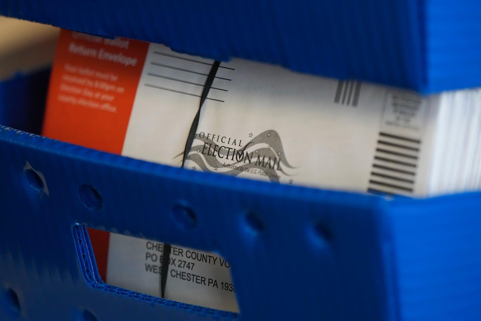 Mail-in ballots sit stacked in a box at the Chester County, Pa., administrative offices, Tuesday, Nov. 5, 2024, in West Chester, Penn.. (AP Photo/Matt Slocum)