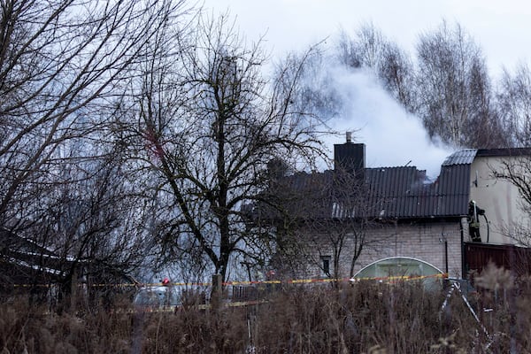 A smoke rises from the place where a DHL cargo plane crashed into a house near the Lithuanian capital Vilnius, Lithuania, Lithuania, Monday, Nov. 25, 2024. (AP Photo/Mindaugas Kulbis)