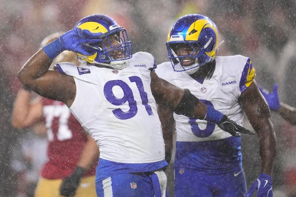 Los Angeles Rams defensive tackle Kobie Turner (91) celebrates with linebacker Byron Young (0) after sacking San Francisco 49ers quarterback Brock Purdy during the first half of an NFL football game in Santa Clara, Calif., Thursday, Dec. 12, 2024. (AP Photo/Godofredo A. Vásquez)