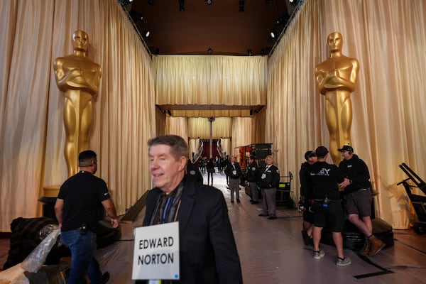 A stand-in walks past Oscar statues in the red carpet area before the 97th Academy Awards in Los Angeles, Saturday, March 1, 2025. (AP Photo/Jae C. Hong)