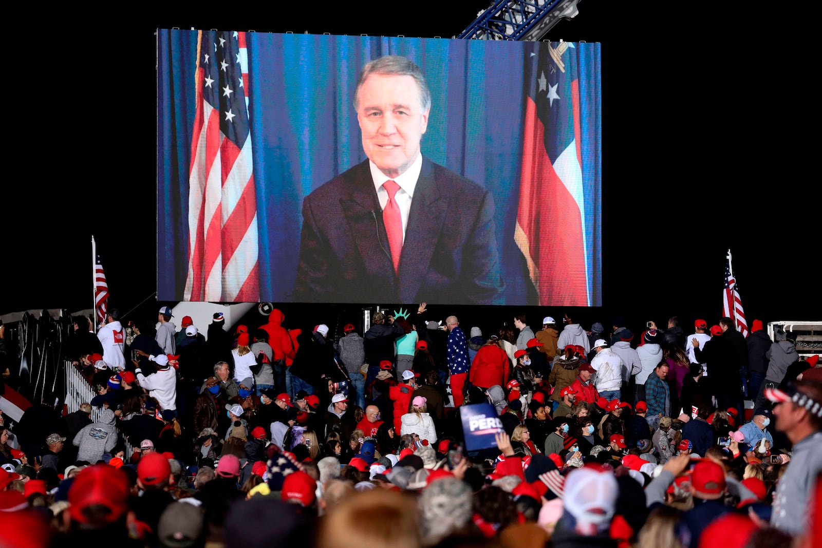 Republican incumbent Sen. David Perdue speaks via video monitor during a rally ahead of a Senate runoff in Dalton, Georgia on Monday, Jan. 4, 2021. (Sandy Huffaker/AFP/Getty Images/TNS)