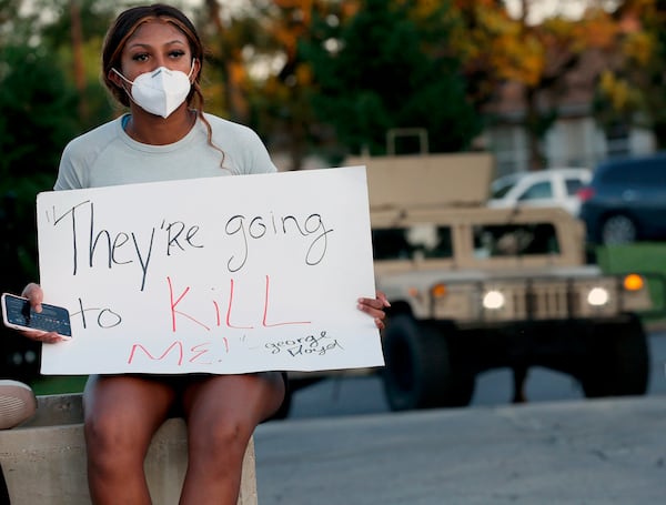  Kennedy Mitchum protests outside the Florissant Police Department with others in Missouri. Merriam-Webster is revising its definition of racism after Mitchum's emails claimed it fell short of including the systemic oppression of certain groups of people.