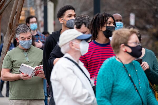 In this file photo, Kelly Breedlove reads a book while waiting in line for Covid testing at the Fulton County Center for Health and Rehabilitation on Dec. 28. Breedlove was getting tested because he just returned from traveling to Key West, Fla., for Christmas. Ben Gray for the Atlanta Journal-Constitution