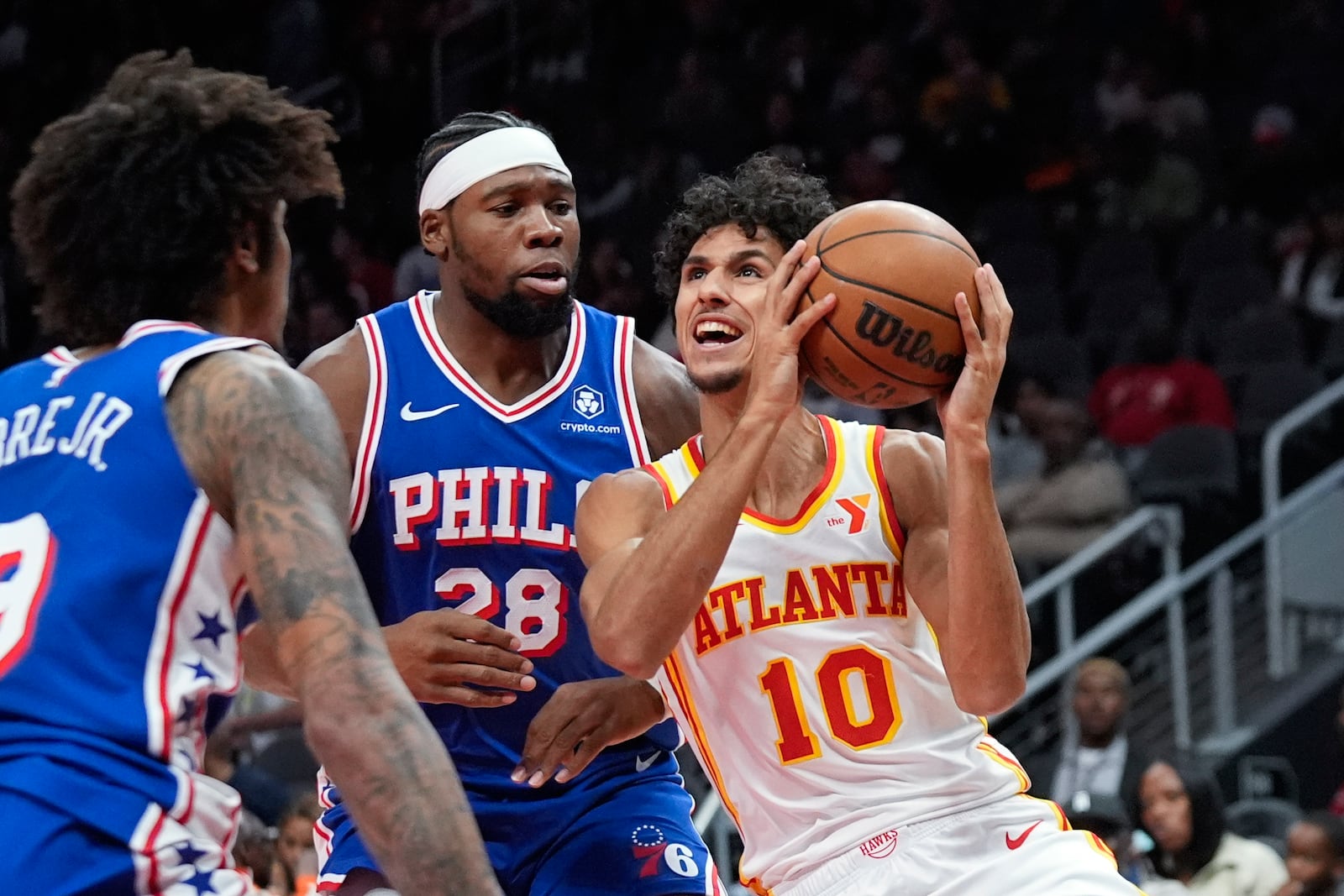 Atlanta Hawks forward Zaccharie Risacher (10) tries to get past Philadelphia 76ers forward Guerschon Yabusele (28) in the first half of a preseason NBA basketball game Monday, Oct. 14, 2024, in Atlanta. (AP Photo/John Bazemore)