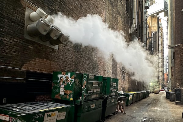 Steam from a restaurant's exhaust fan is blown down as alley as an Arctic blast brings single-digit temperatures with wind chills below zero on Thursday, Dec. 12, 2024, in Chicago. (AP Photo/Charles Rex Arbogast)