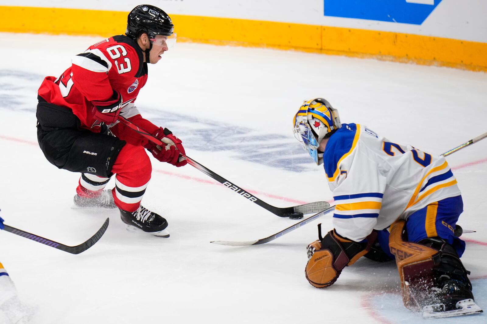 New Jersey Devils' Jesper Bratt, left, skates past Buffalo Sabres' Devon Levi during the NHL hockey game between Buffalo Sabres and New Jersey Devils, in Prague, Czech Republic, Saturday, Oct. 5, 2024. (AP Photo/Petr David Josek)